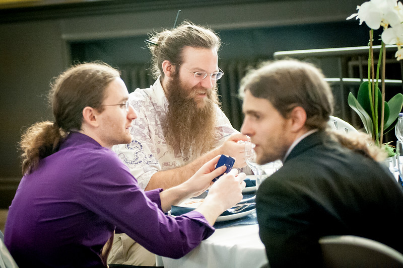 Friends examining cards at a table.
